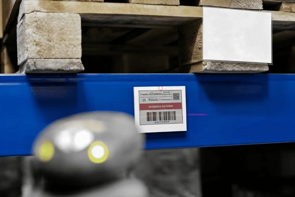 Large-format electronic shelf labels used in warehouse bin locations showing lot numbers and reorder triggers